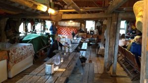 Rustic wooden dining hall with long communal tables inside Tinder Hearth, Acadia National Park.