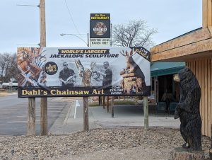 Exterior view of a rustic gift shop with carved sign and large display window