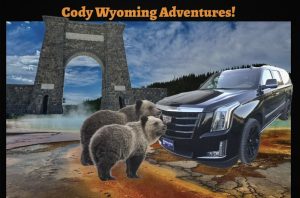 View of Roosevelt Arch at Yellowstone National Park with two bears and a dark SUV nearby, framed by a blue sky.