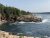 Rocky shoreline along Gorham Mountain Trailhead with pine trees, rugged cliffs, and blue Atlantic in Acadia National Park.