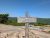 Gorham Mountain Trailhead at Acadia National Park with a weathered wooden sign and rocky foreground under a clear blue sky.