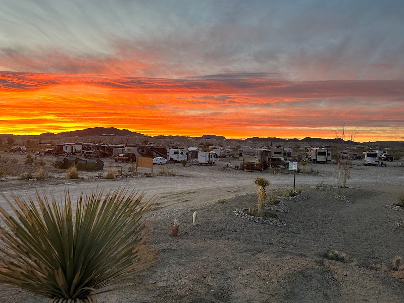 Sunset over a desert campground with RVs at RoadRunner Travelers RV Park in Big Bend National Park.