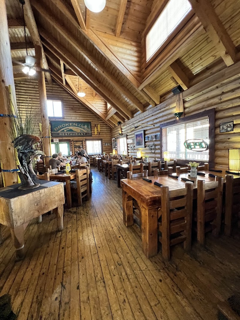 Rustic log dining room in Arches National Park with wooden tables and chairs, vaulted cedar beams, and guests dining.
