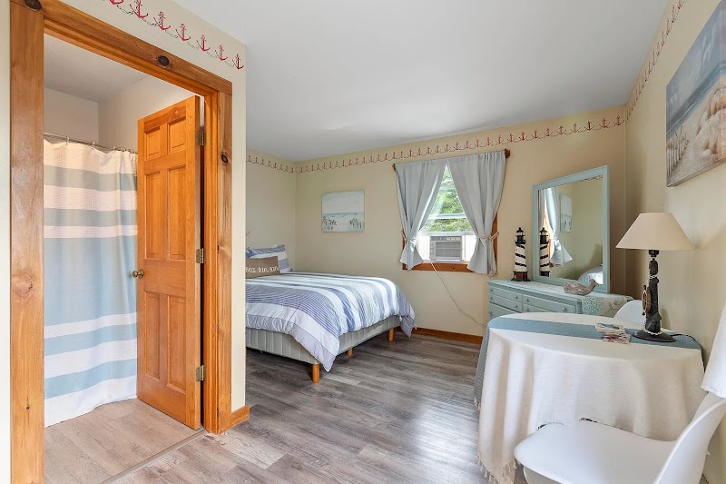 Cozy seaside-style bedroom in Acadia National Park with striped blue-and-white bedding and a window view.