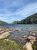 Rocky shoreline along Jordan Pond in Acadia National Park, with clear water and evergreen shores.