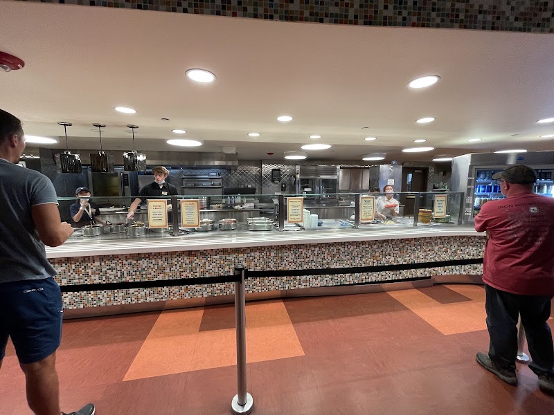 Inside Yellowstone National Park, a long glass-service counter with a mosaic tile front and customers waiting for service.