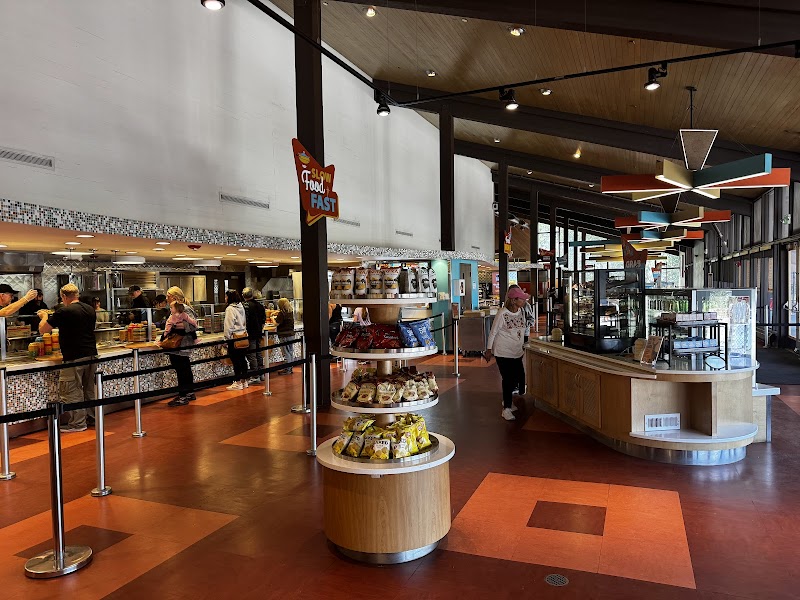 Inside a Yellowstone National Park general store with a curved pastry stand, lunch line, warm wood ceilings.