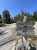 Weathered wooden trail sign on granite with arrow boards at Acadia National Park, surrounded by pines under a bright blue sky.