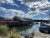 Beal's Lobster Pier along Acadia National Park's shore, with boats, a dockside restaurant, and bright red umbrellas.