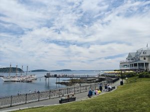 Bar Harbor Shore Path in Acadia National Park along the harbor, with boats, a pier, and a seaside promenade.