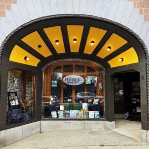 Bar Harbor storefront for a kitchen and bar near Acadia National Park, with a curved yellow awning and brick facade.