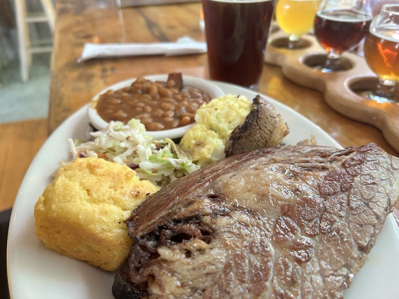 Smoked beef brisket with baked beans, cornbread, coleslaw, and mashed potatoes on a plate at Acadia National Park.