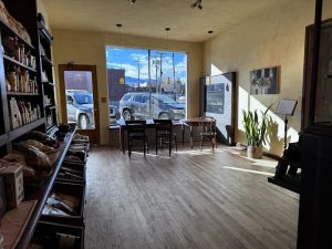 Interior dining area of a Yellowstone National Park restaurant, with large front windows, wooden floors, and casual seating.