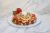 Banana-strawberry waffle dessert topped with whipped cream, nuts, and chocolate drizzle on a white marble surface in Yellowstone National Park.