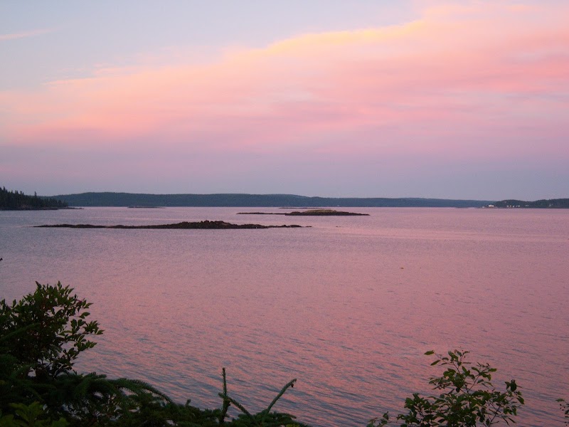 Harborside at Acadia National Park showcases a pink sunset over tranquil harbor waters.