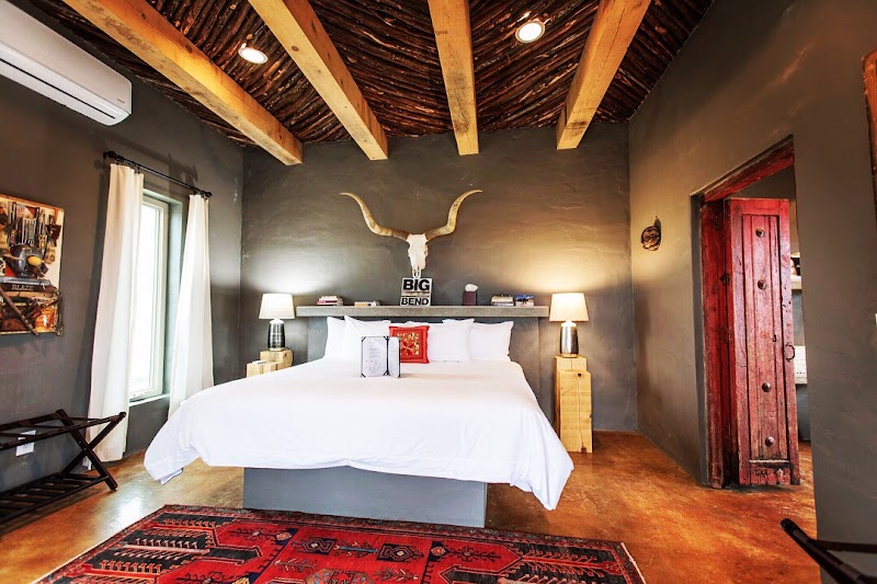 Guest room with white bedding and rustic longhorn skull decor in Big Bend National Park.