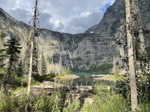 Lincoln Lake Campground sits beside a tranquil alpine lake framed by towering Glacier National Park peaks.