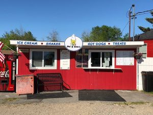 Bright red ice cream stand in Acadia National Park offering shakes, hot dogs, and treats.