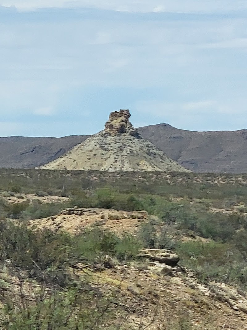 West Entrance of Big Bend National Park featuring a rugged, isolated rock formation rising from desert terrain.