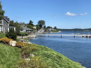 Castine harbor in Acadia National Park, with colorful houses along the waterfront and a wooden pier.
