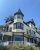 Castine townhouse with a turreted tower stands under a clear blue sky in Acadia National Park.