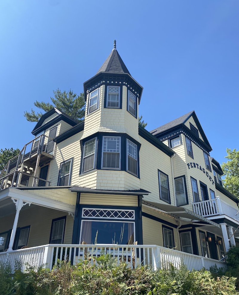 Castine townhouse with a turreted tower stands under a clear blue sky in Acadia National Park.