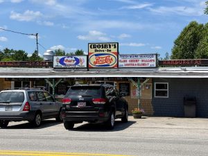 Drive-In restaurant exterior in Acadia National Park with a retro sign and vehicles in the lot.