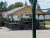Drive-in restaurant pavilion at Acadia National Park with a shaded deck, picnic tables, and a small white building in the background.