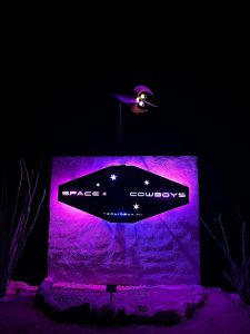 Neon purple-lit signage at night in the Terlingua area of Big Bend National Park, a roadside landmark with desert surroundings.