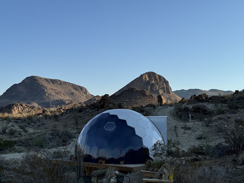 Space Cowboys dome lodging in Big Bend National Park; a blue geodesic dome sits in a desert landscape with mountains in the distance.