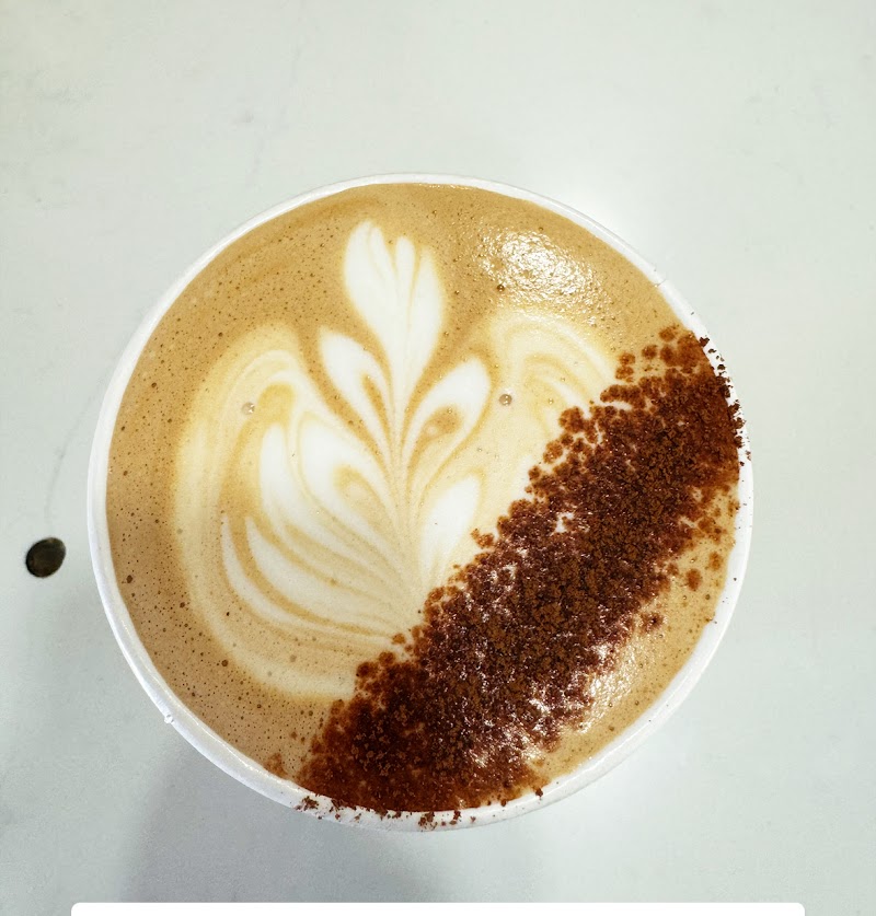 Latte with leaf latte art in a white cup and a chocolate crumble border, Arches National Park.
