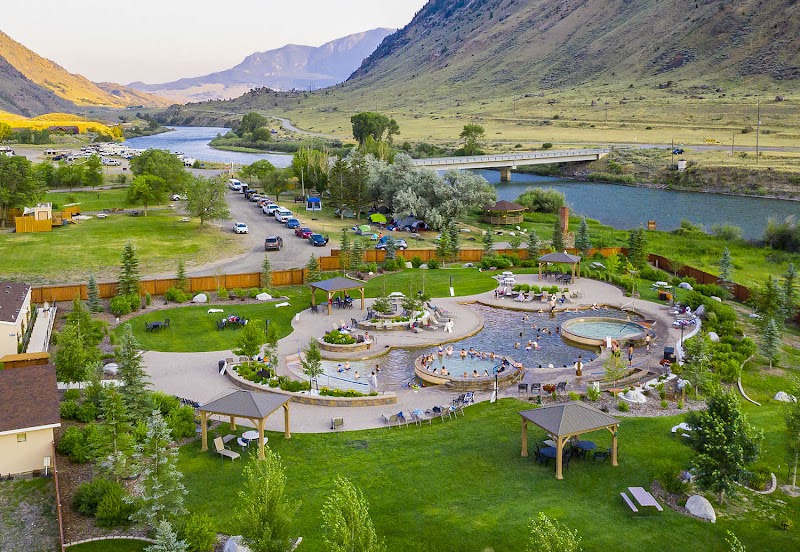Lawn with circular pools, gazebos, and outdoor seating in Gardiner near Yellowstone National Park; river and bridge in the background.