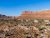 Desert campground with white canvas tents dotting the rocky terrain beneath red mesas in Arches National Park.