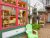 Vibrant gift shop storefront with pink and green trim, large display windows, and hanging flower baskets in Acadia National Park.