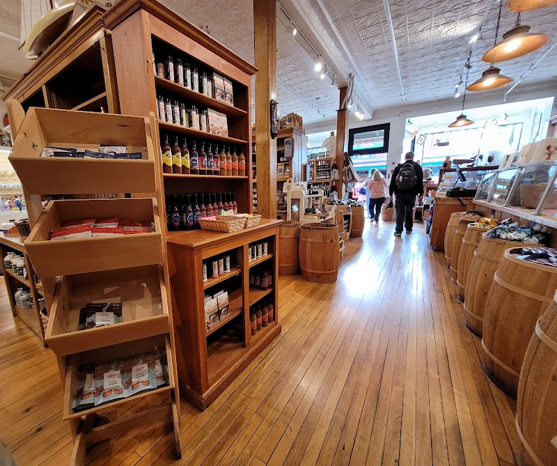 Inside a rustic gift shop in Acadia National Park with tall wooden shelves, barrels, and a glass case along a polished wood floor.