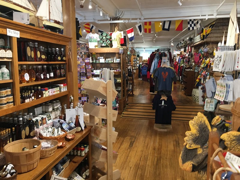 Cozy gift shop interior in Acadia National Park with wooden shelves full of bottles, jars, souvenirs, tees, and nautical decor