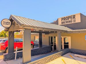 Stone-walled burger spot with a metal roof, string lights, and parked cars outside, signage visible in Arches National Park.