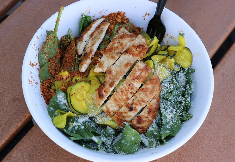 Arches National Park bowl of salad with sliced grilled chicken, mixed greens, zucchini, yellow squash, and a light cheese dusting.