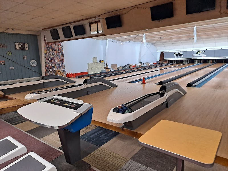 Interior of a candlepin bowling alley in Acadia National Park, showing lanes, ball return, and seating area.