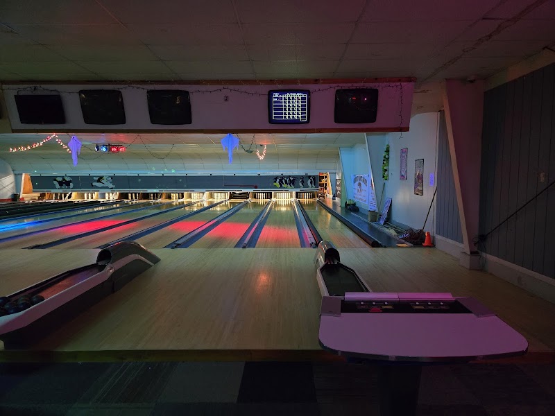 Candlepin bowling alley interior in Acadia National Park, with glowing lanes, neon lighting, and a digital scoring screen above the pins.