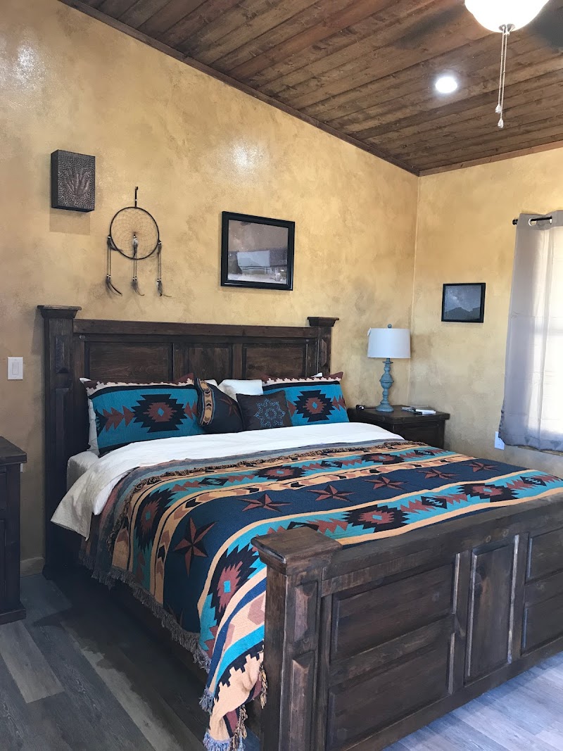 Southwestern-style bedroom in a rustic lodge room at Big Bend National Park featuring a carved wooden bed.