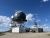 Large radar dome on a metal lattice with satellite dishes and white utility buildings in Yellowstone National Park.