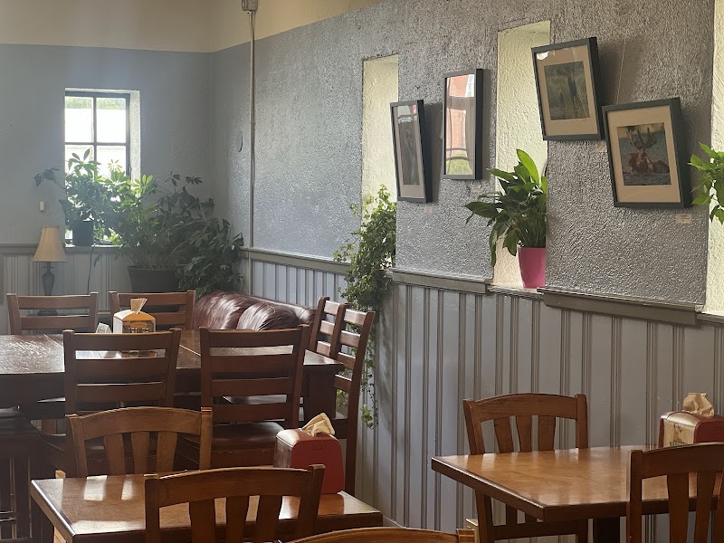 Interior of Flexit Cafe in Acadia National Park with wooden tables, plants, and framed art.