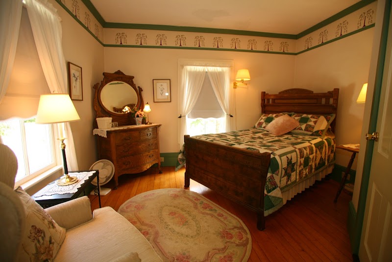 Cozy guest room at an Acadia National Park inn featuring a carved wooden bed and patchwork bedding.