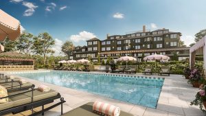 Sunny poolside at a resort hotel with pink striped umbrellas and lounge chairs, Acadia National Park.