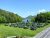 Outdoor seating on a grassy lawn overlooking Jordan Pond and surrounding trees at Acadia National Park in summer.