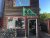 Wooden storefront at Acadia National Park with a green cyclist sign, bikes lined outside, and a partly open door showing shop interior.