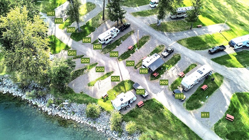 Rocky lakeshore inside Glacier National Park with camping area and towering mountain peaks