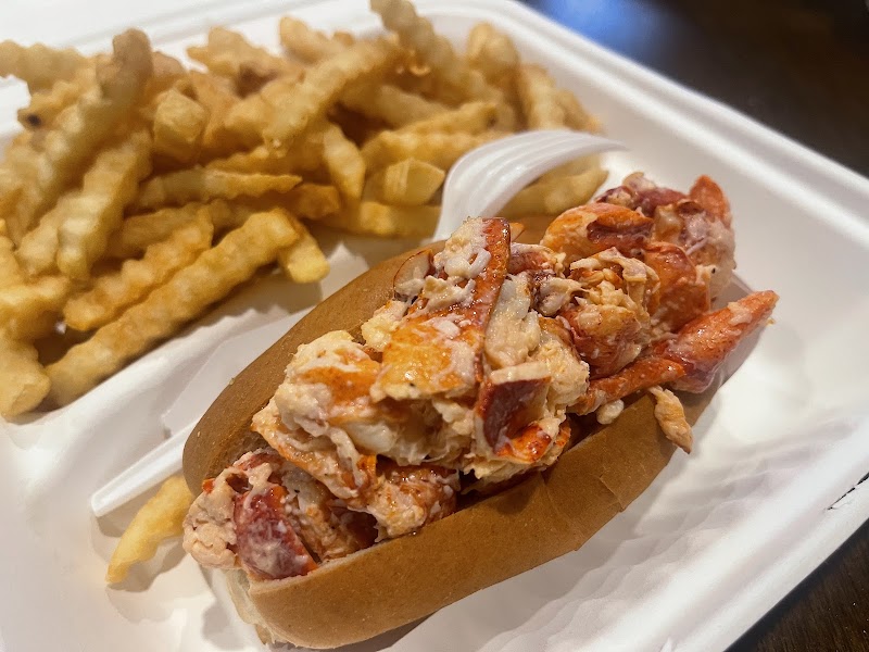 Lobster roll with fries served in a bun at a seaside eatery in Acadia National Park near Bar Harbor.