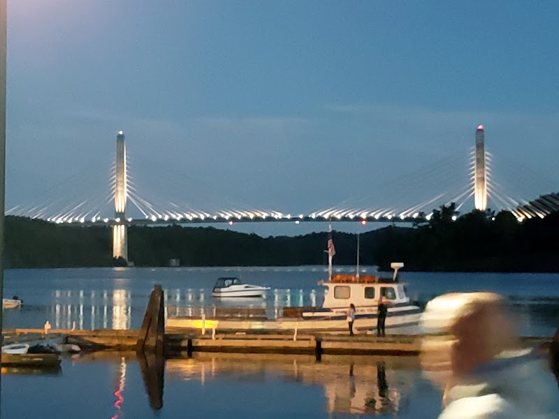 Bucksport waterfront at dusk with the illuminated Penobscot Narrows Bridge spanning the river near Acadia National Park.